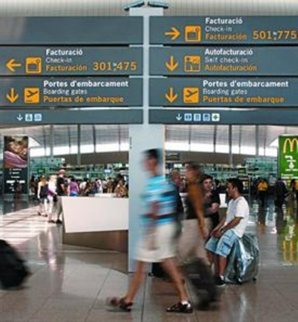 Passatgers amb els equipatges a la terminal T-1 de l’aeroport del Prat.