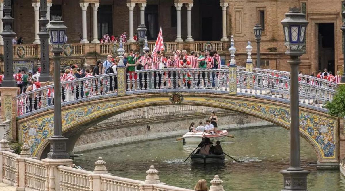 Aficionados del Athletic Club de Bilbao y del Real Club Deportivo Mallorca pasean por la Plaza de España de Sevilla este sábado antes del encuentro de la final de la Copa del Rey que ambos equipos disputarán esta noche en el estadio de La Cartuja de la capital andaluza.