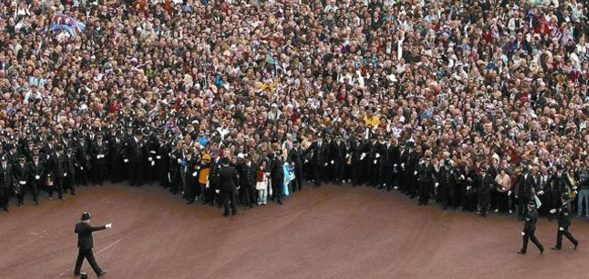 Una multitud a l’avinguda del Mall espera les indicacions de la policia per situar-se davant del palau de Buckingham, ahir.