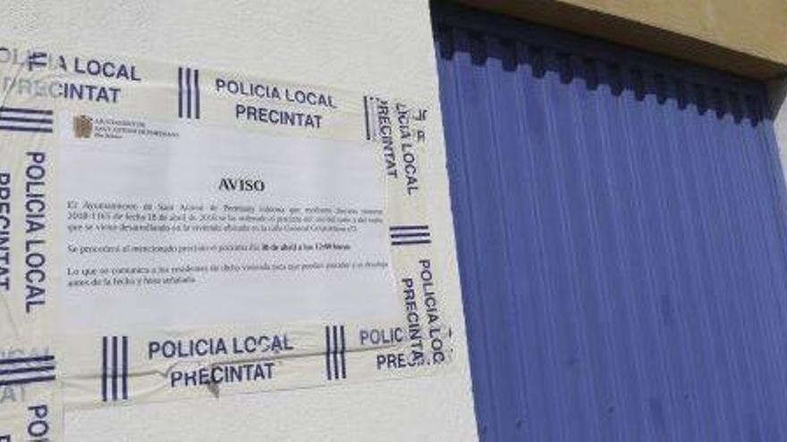 Uno de los accesos al edificio con el aviso municipal.