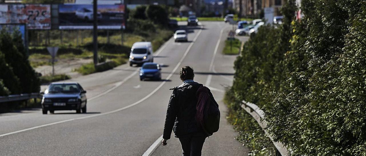 Una joven, llegando a Lugones por el arcén de la carretera. | J. R.