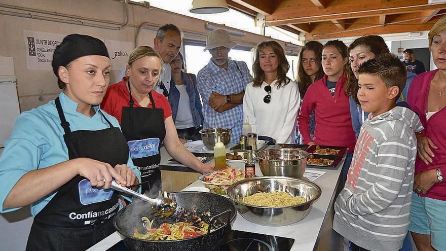 Las cocineras de O Rincón de Cela, ayer, preparando un wok de pulpo en la plaza de Bueu. // G.N.