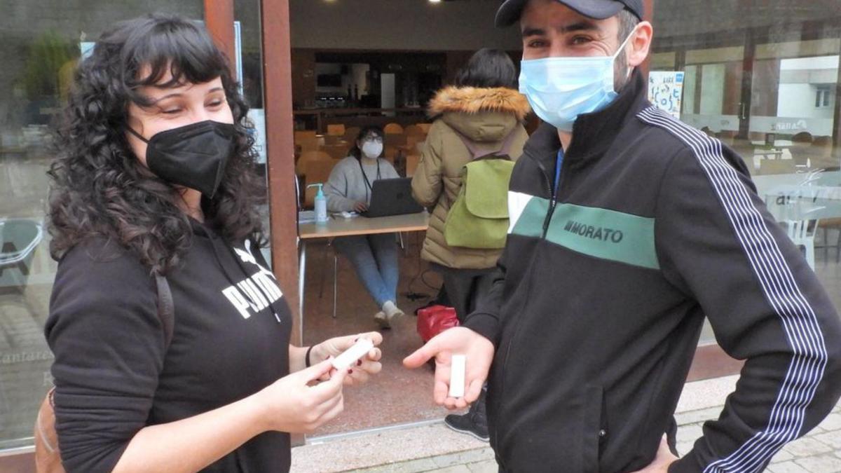 Dos jóvenes muestran su test de antígenos, en Allariz.  | // FERNANDO CASANOVA