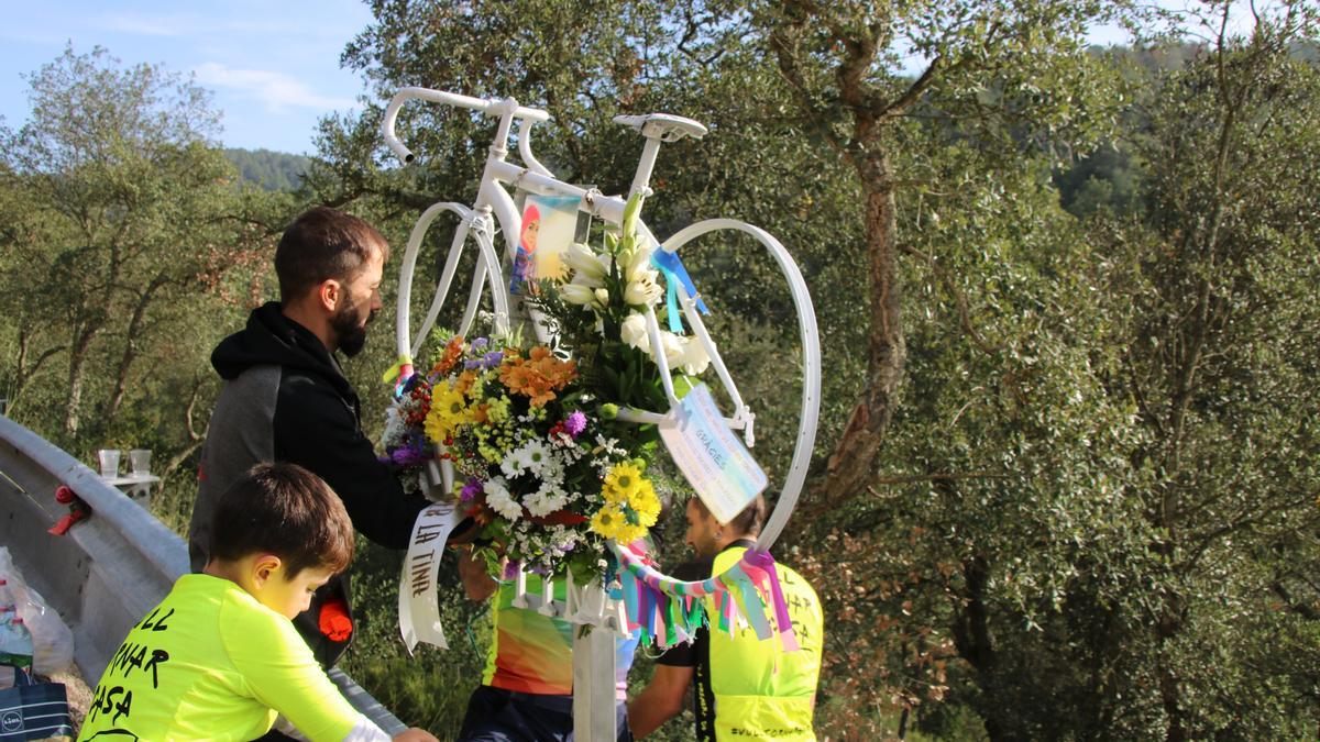 Amics de la Tina penjant un ram de flors pel primer aniversari de la seva mort a la bici que van col·locat al punt on va ser atropellada