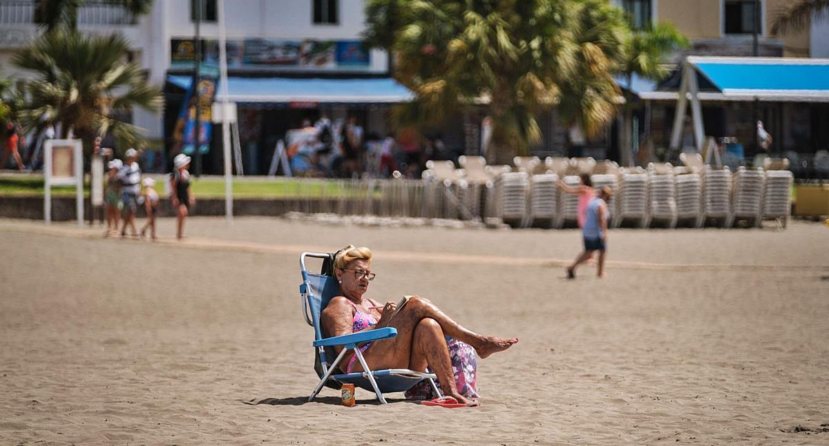 Una mujer toma el sol en la playa de Los Cristianos. | | ANDRÉS GUTIÉRREZ