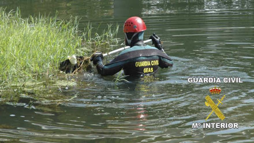 Un buzo del Geas rastrea una orilla del río Cea cerca de Fuentes. Sobre estas lineas, el fallecido Miguel Quijadas.
