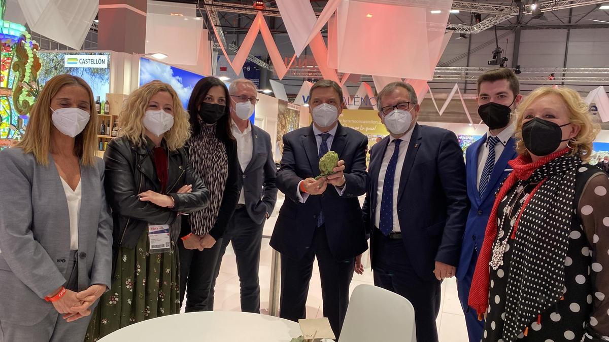 El ministro de Agricultura, Luis Planas, sostiene una alcachofa de Benicarló en su visita al estand de Castellón en Fitur, junto a José Martí, Virginia Martí y Eva Redondo, entre otros.