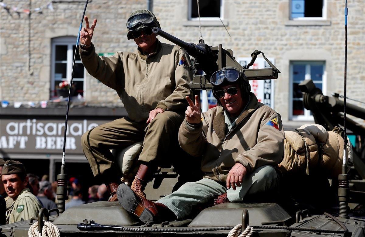 Entusiastas de la Segunda Guerra Mundial posan vestidos con uniformes durante un desfile celebrado en Sainte-Marie-Du-Mont, Francia.