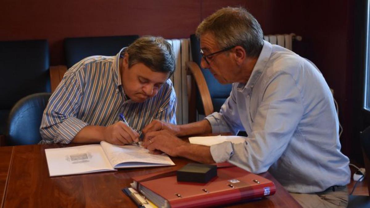 Francisco Bustelo, junto a su hermano Pepe, firma en el libro de honor del Ayuntamiento. | J. Riestra