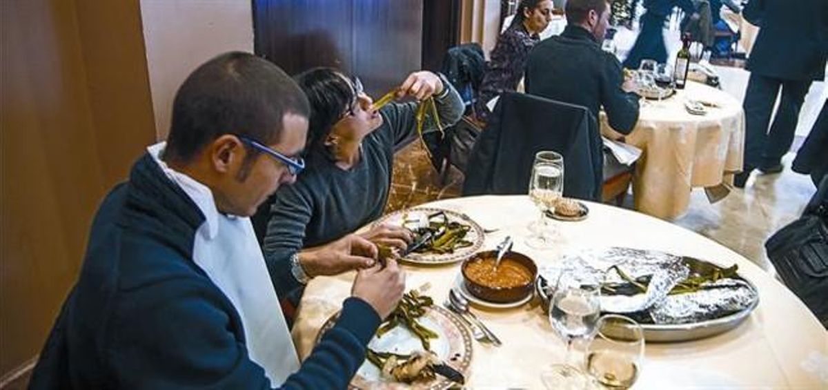 Uns comensals degusten una calçotada en un restaurant, la setmana passada.