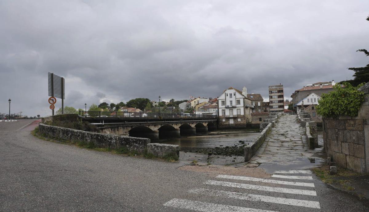 El asfalto toca con la vía pétrea del puente medieval de A Ramallosa en el extremo de Baiona.
