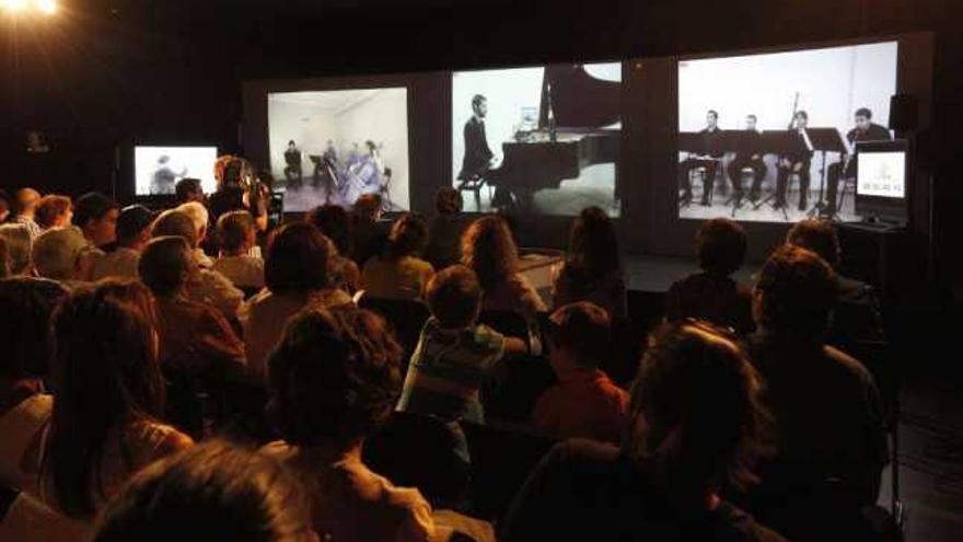 Espectadores, en el Marco, contemplando a los músicos a través de pantallas.  // Ricardo Grobas