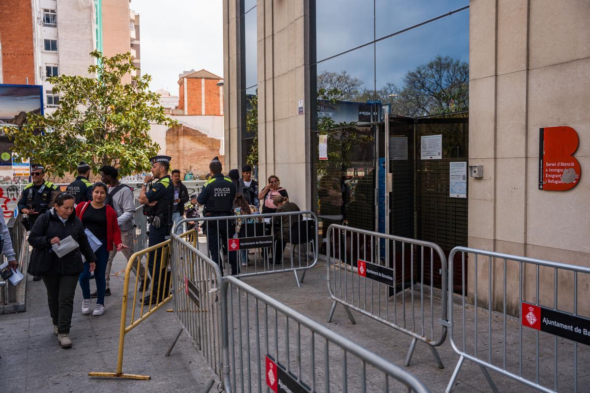 Caos y una larga cola de personas que esperan regularizar su situación en España en la Oficina de Benestar Social i Família de Barcelona-Sants/Eixample.