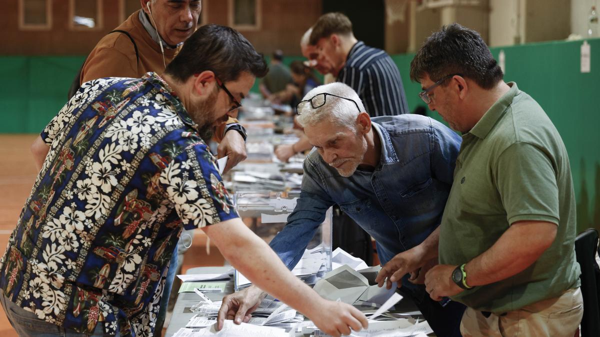 Los miembros de una mesa electoral proceden a la apertura de las urnas para el recuento de votos.