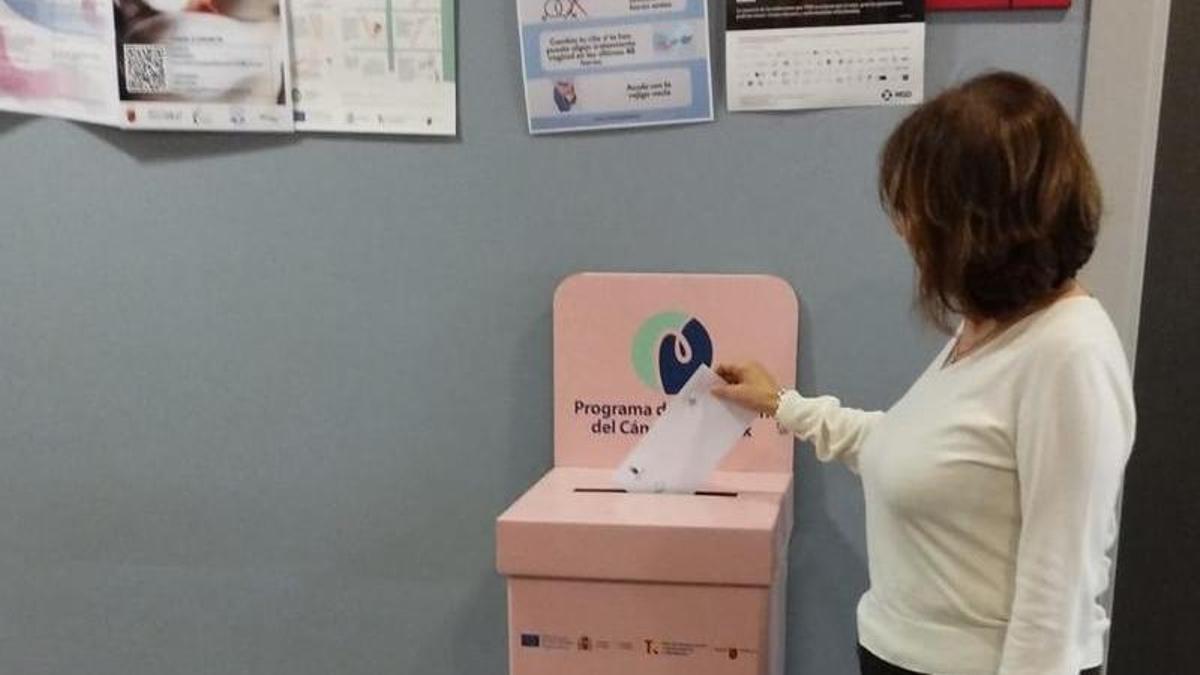 Una mujer deposita la prueba en el buzón rosa en el centro de Floridablanca.