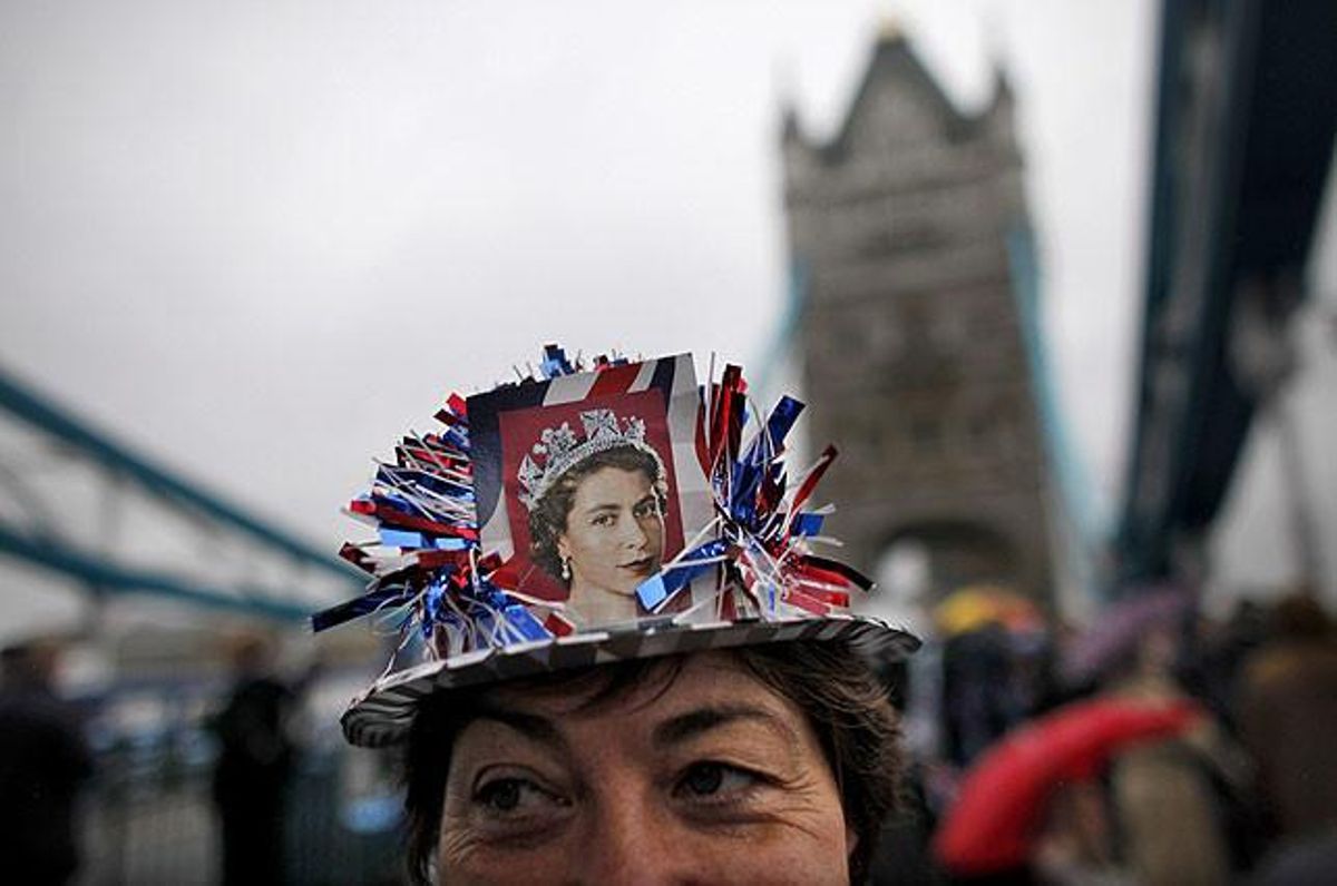 Una dona llueix la fotografia d’una jove Isabel II a la riba del riu Tàmesi a Tower Bridge.