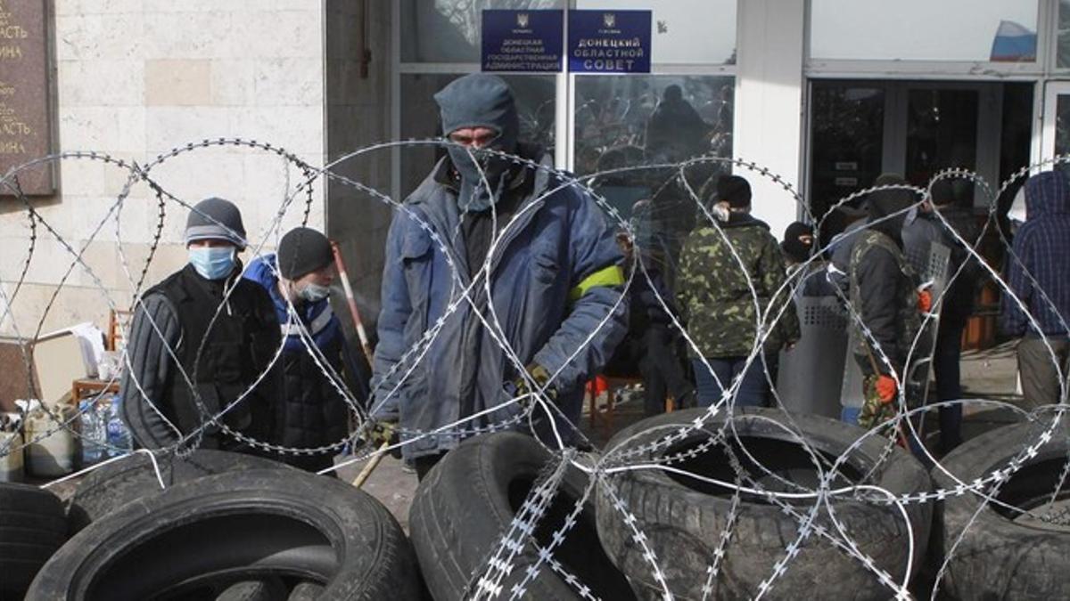 Manifestantes prorrusos levantan una barricada frente a un edificio ocupado de la administración regional en Donetsk, esta mañana.