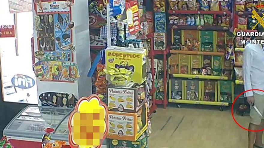 Uno de los detenidos con el cuchillo en la mano en el interior de la tienda