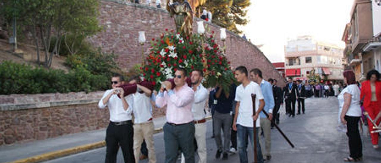 Clavarios o cofrades, jóvenes del Puig, transportando en procesión la imagen de Sant Roc.
