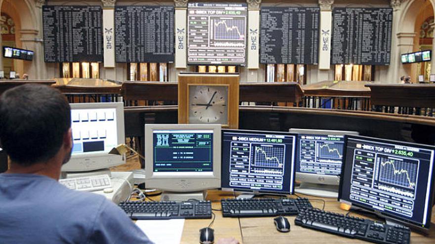 Un operador controla diverses pantalles a la seu de la borsa de Madrid.