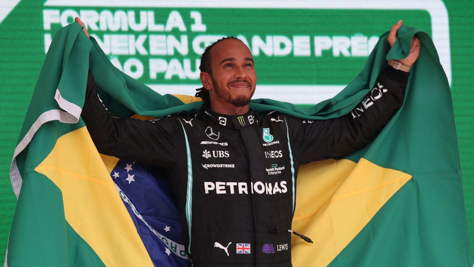 Hamilton, con la bandera de Brasil, en el podio de Interlagos.