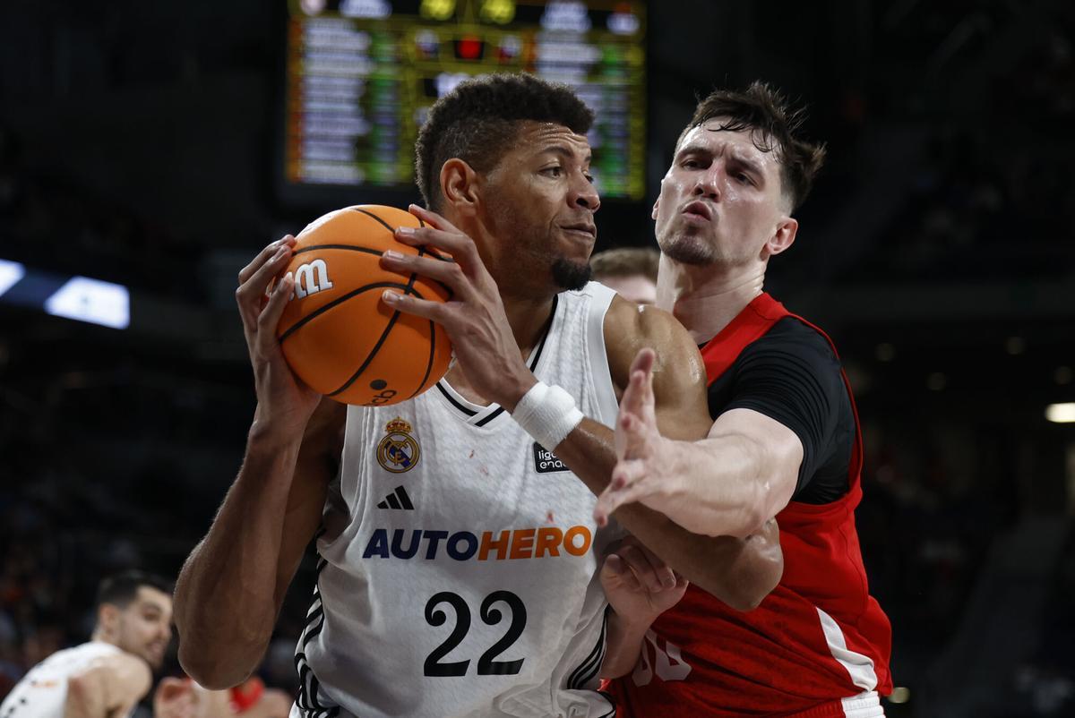 El pívot del Real Madrid,Walter Tavares (i) con el balón ante el alero del UCAM Murcia Rodions Kurucs durante el partido de Liga Endesa que disputan este domingo en el Movistar Arena de Madrid
