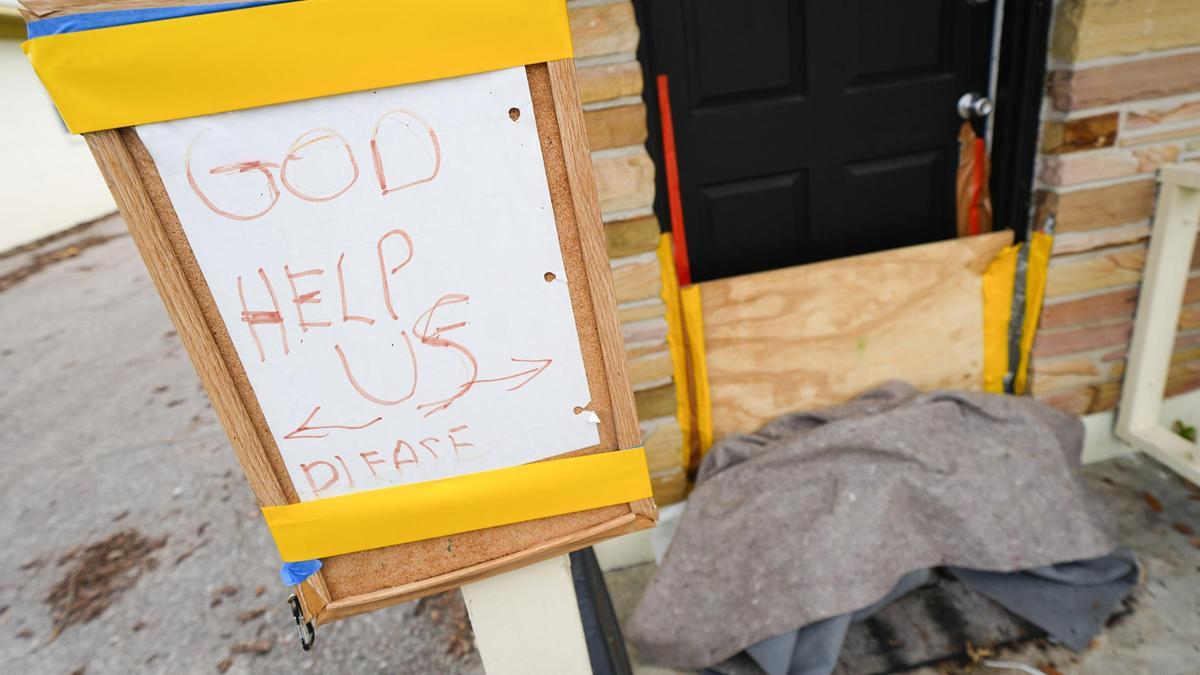 Un carte con el mensaje &quot;Que Dios nos ayude&quot; a la entrada de una vivienda en Tampa, Florida, este martes.