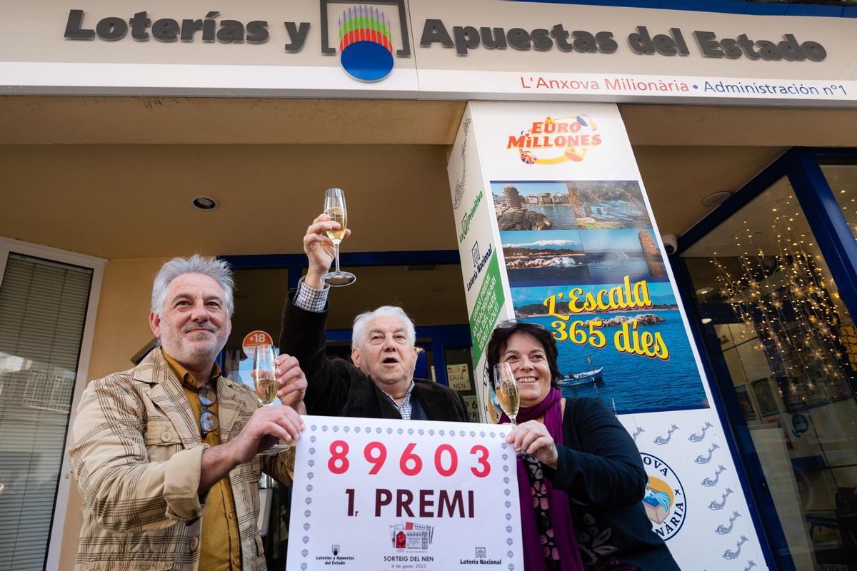 Los propietarios de la administración número 1 de L’Escala (Girona) posan con el número agraciado con el primer premio de la Lotería de El Niño este viernes. La administración, que se llama l’Anxova Milionària, ha vendido todas las 40 series del primer premio de la Lotería del Niño 2023, con lo que ha repartido 80 millones de euros, todos en ventanilla. EFE/ David Borrat