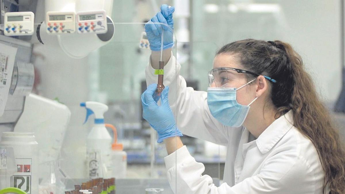 Una técnico examina una muestra en un laboratorio.