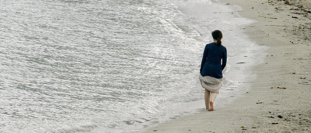 Una mujer camina por la playa