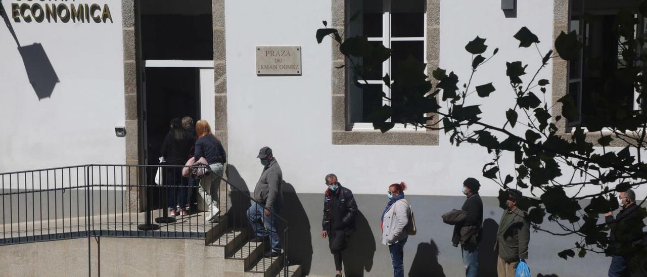 Grupo de personas esperando para acceder a la Cocina Económica de Santiago.   | // XOÁN ÁLVAREZ