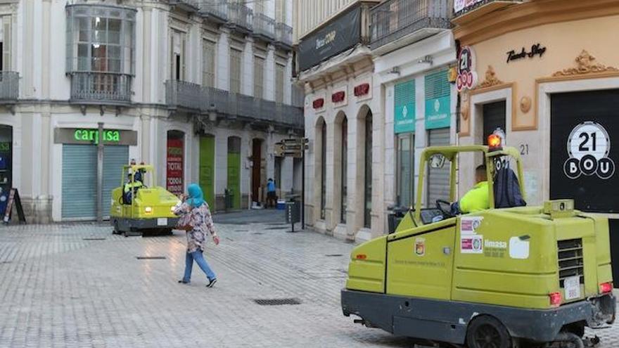 Dos máquinas barredoras repasan el pavimento en la calle Granada y plaza de Spínola tras la Feria.