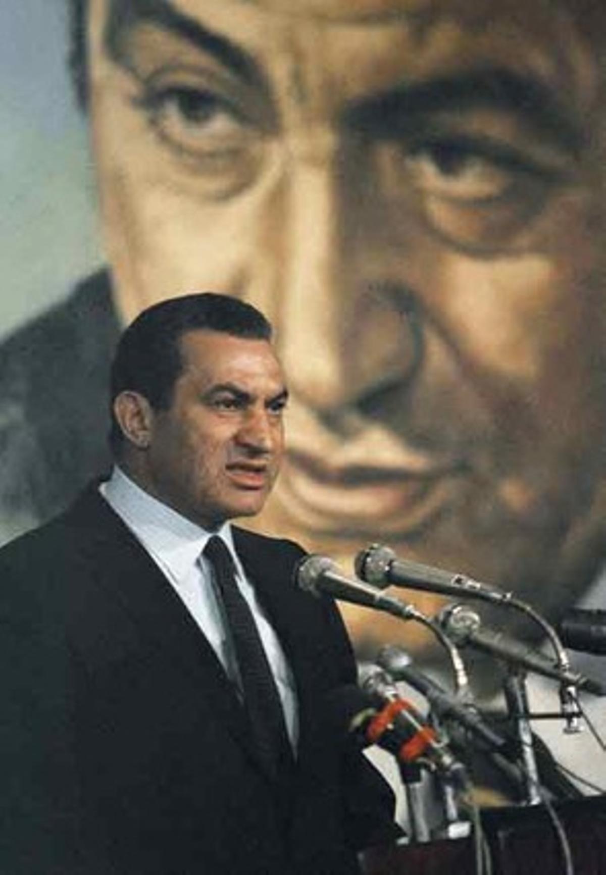 El dirigente da un discurso ante un gran cartel con su retrato.