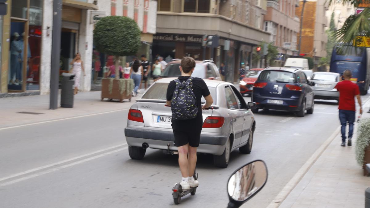 Un joven circula por la Avenida Juan Carlos I en patinete sin casco ni chaleco reflectante, como refleja la ordenanza