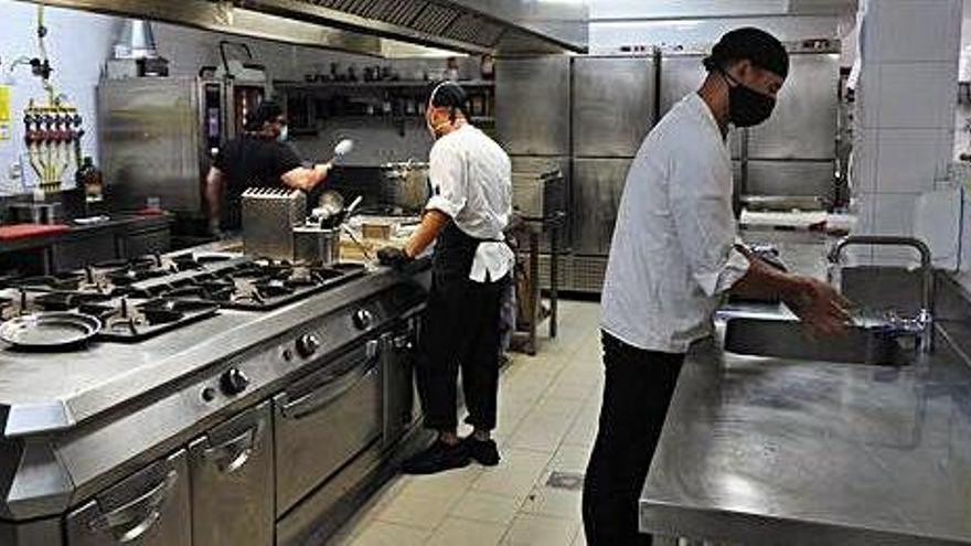 Dos trabajadores en la cocina de un establecimiento turístico de Formentera.