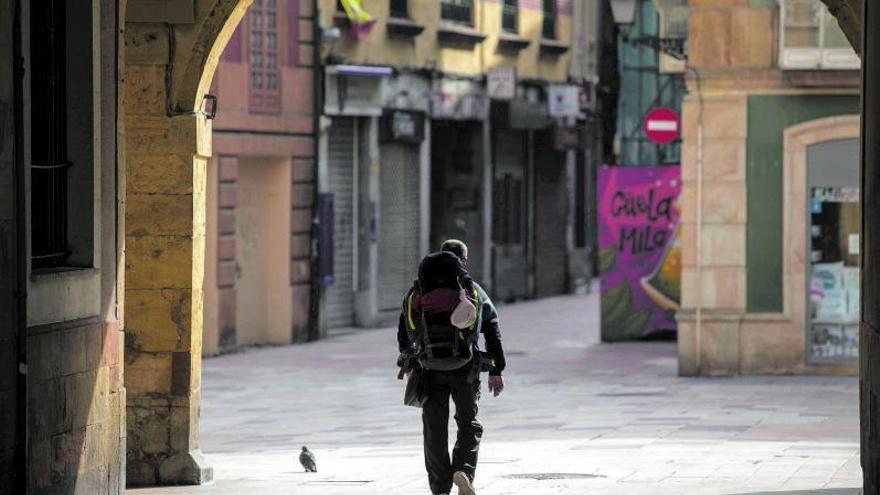 Un peregrino sigue el itinerario del Camino Primitivo por el casco histórico de Oviedo. | Miki López