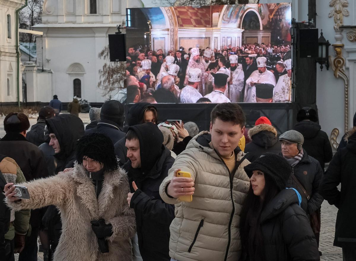 La gente se toma selfies cerca de la Catedral de Uspenskyi , en el recinto del monasterio de Kyiv Pechersk Lavra, utilizado anteriormente por la rama de la Iglesia Ortodoxa Ucraniana leal a Moscú.