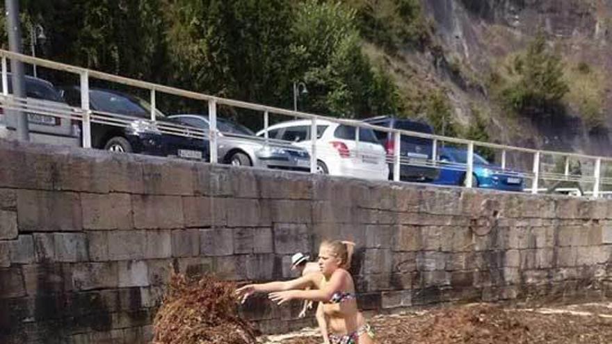 Una bañista, limpiando la playa de El Escanu el pasado lunes.