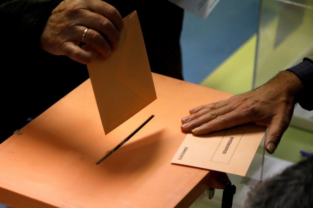 GRAF6029. MADRID, 10/11/2019.- Un elector deposita el sobre con las papeletas en una urna en el CEIP Ortega y Gasset de Madrid para las elecciones generales en las que millones de españoles con derecho al voto eligen de nuevo a sus representantes en el Congreso y en el Senado. EFE/David Fernández