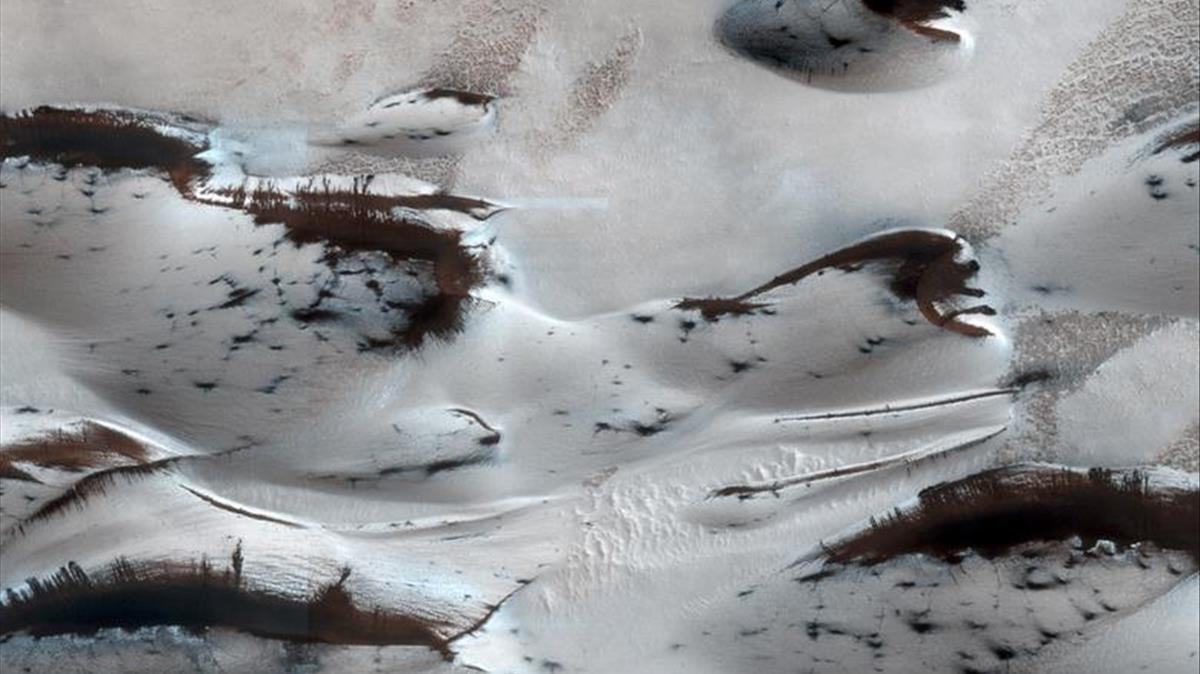Las dunas de arena más al norte se ven cuando comienzan a emerger de su cubierta invernal de hielo seco de dióxido de carbono estacional