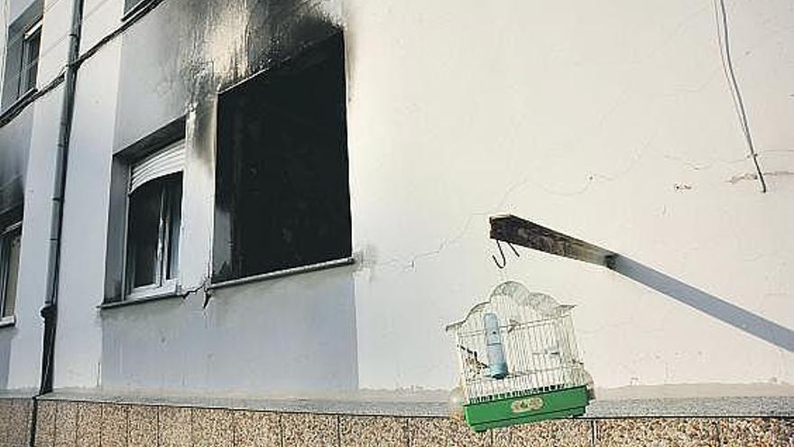 Una vivienda afectada por la explosión, con un jilguero enjaulado en primer término.