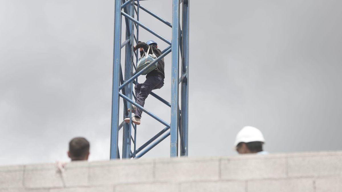 Un hombre se encarama a una grúa en una obra del Coll d'en Rabassa
