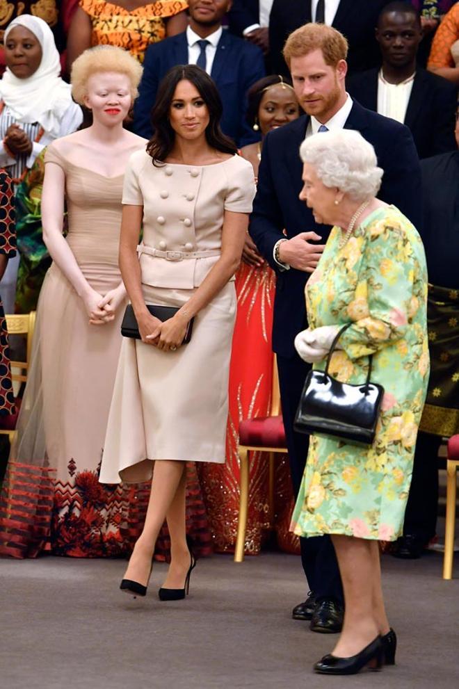 Meghan Markle con un conjunto rosa de Prada junto al príncipe Harry y la reina Isabel II