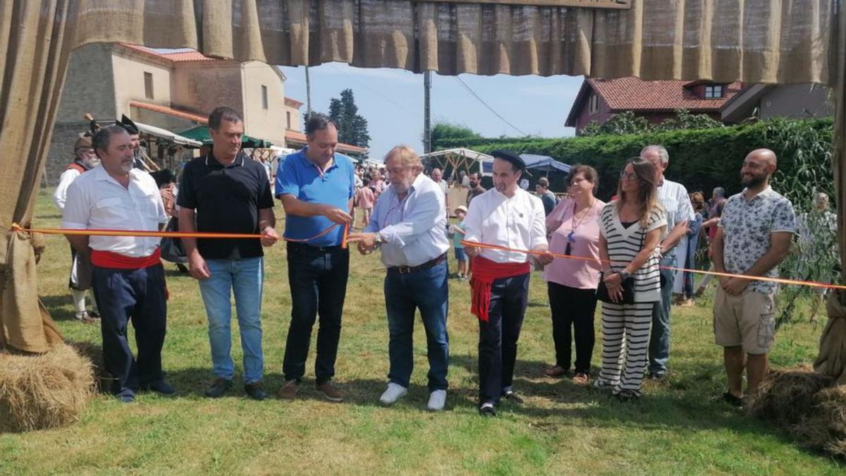 Alejandro Vega y el pregonero Luis  Rivaya, en el centro, en la apertura del Mercáu de Oles, junto a miembros de la comisión de fiestas y concejales de Villaviciosa. | V. Alonso