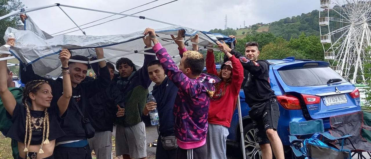 Un grupo de jóvenes de Toledo y Madrid despliega un toldo cerca de la zona de acampada del Aquasella. | M. V.