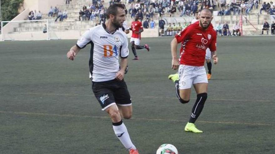 El llosetí Campins realiza un centro ante la oposición de un jugador del Pobla.