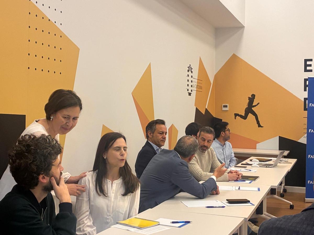 Leticia Bilbao, de pie, hablando con participantes en el encuentro impulsado por FADE y el Ayuntamiento de Avilés.