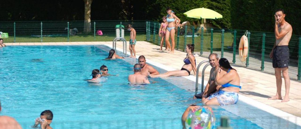 Un grupo de personas combate el calor en una piscina. |
