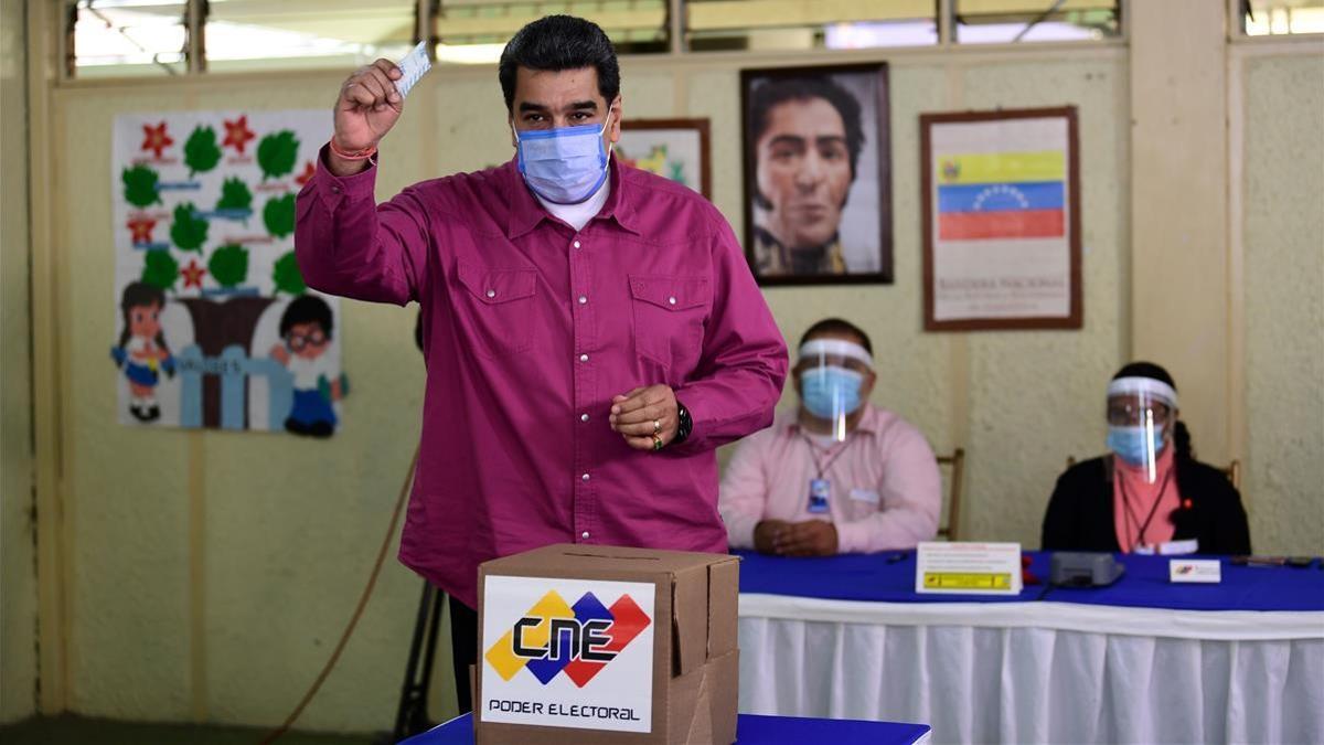 Venezuelan President Nicolas Maduro casts his vote at a polling station in the Simon Rodriguez school in Fuerte Tiuna  Caracas  on December 6  2020 during Venezuela s legislative elections  - Polls opened early December 6 in legislative elections set to tighten Venezuelan President Nicolas Maduro s grip on power and weaken his US-backed rival  who is leading a boycott of the polls he calls a fraud  Maduro and his allies are set to dominate the legislative elections  which victory will give them control of the National Assembly  the only institution not yet in its hands  (Photo by YURI CORTEZ   AFP)