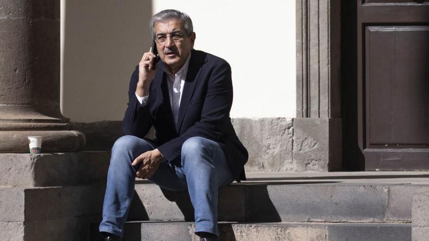 Román Rodríguez habla por teléfono en las escaleras del patio del Parlamento.